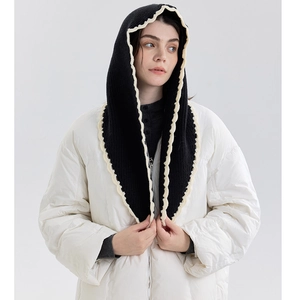 Detail of black knitted balaclava with cream ruffled trim and cozy neck protection