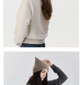 Close-up of brown pointed wool knit beanie and beige textured sweater for winter