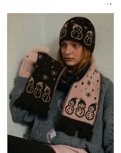 Detail of wool blend knitted scarf with cartoon snowman jacquard pattern and fringe tassels