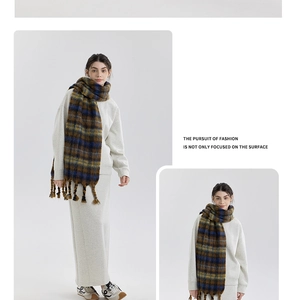 Close-up of thick checkered scarf with long tassels in navy, yellow and brown tones