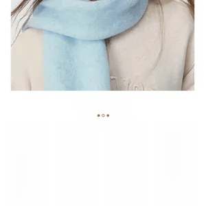 Detail of light blue knitted scarf texture paired with a beige sweater for winter warmth