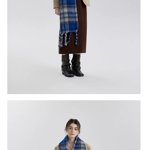 Detail of blue and grey plaid scarf with long tassels and beige blazer styling