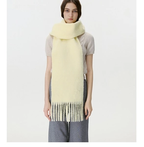 Detailed close-up of light yellow knit scarf with fringe tassel texture and soft finish