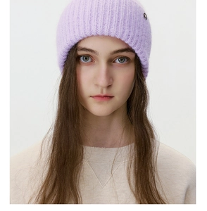 Detailed knit texture and metallic emblem of a lavender ribbed winter beanie for women