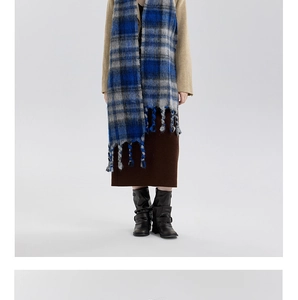 Detail of soft blue and grey checkered scarf with thick fringe tassels for winter wear
