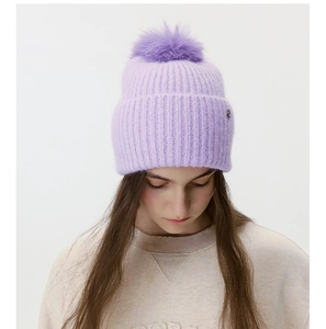 Close-up of lavender knit beanie with premium faux fur pom-pom and small metal logo