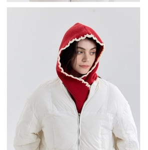 Close-up of red knit balaclava hood featuring white wavy scalloped edges and soft wool texture