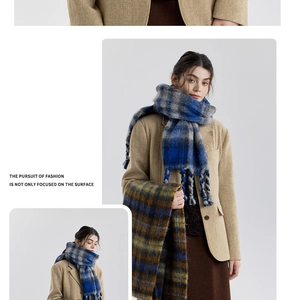 Close-up of thick blue and grey plaid scarf with soft woven fringe detail on the edges