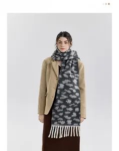 Detail of soft leopard print knit scarf with white fringes for winter warmth