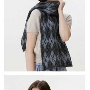 Detail of classic charcoal and black argyle knit scarf with soft texture and drape