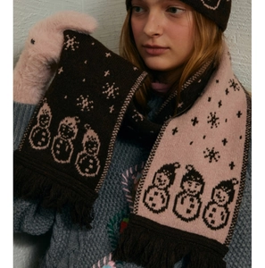 Detail of wool blend knit scarf featuring cartoon snowman jacquard and fringe edges