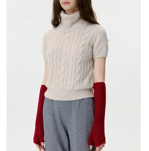 Close-up of deep red cable-knit fingerless gloves and off-white sweater texture