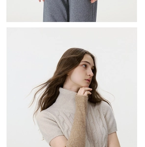 Close-up of beige cable-knit high-neck sweater with matching light brown arm warmers