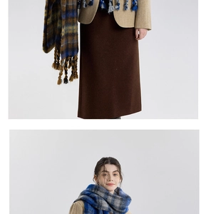 Detail shot of the thick blue and grey plaid scarf with long decorative tassels