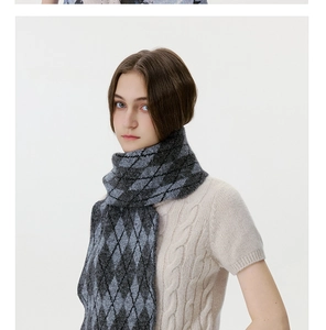 Close-up of grey and black argyle knit scarf paired with cable-knit beige short sleeve sweater