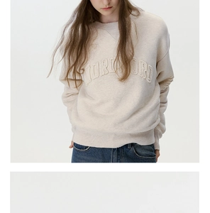 Detail showing vintage ribbed crewneck stitching and thick cotton texture on apricot sweatshirt