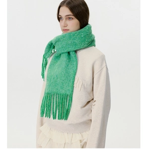 Detail showing the fluffy texture and long fringes of this premium grass green winter scarf