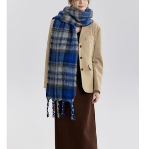 Detail of blue and grey checkered scarf featuring soft brushed texture and thick tassels