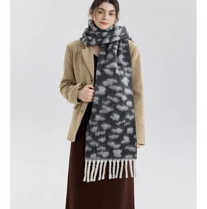 Close-up of leopard print scarf featuring thick white twisted tassels and plush texture