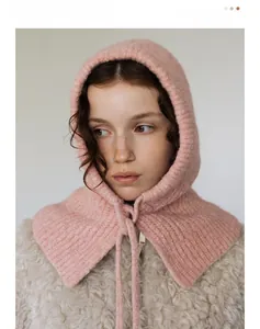 Close-up of pink knitted balaclava with warm wool texture and adjustable drawstring ties