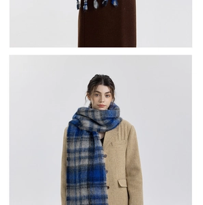 Close-up of thick blue and grey plaid scarf with woven tassels for winter warmth
