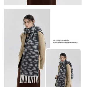 Detail showing soft leopard print scarf with white thick tassels on wool coat