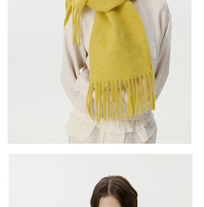 Close-up of vibrant yellow wool scarf with long tassels for a warm and cozy winter look