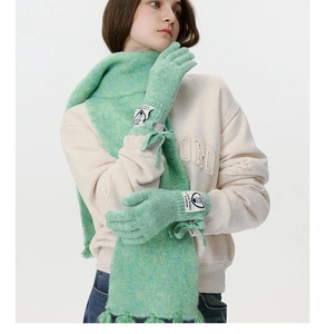 Detail von mintgrünen Strickhandschuhen mit Schleifendekor und gewebtem Stofflabel