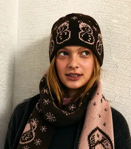 Detail of wool blend knitted beanie and scarf set featuring cartoon snowman jacquard pattern