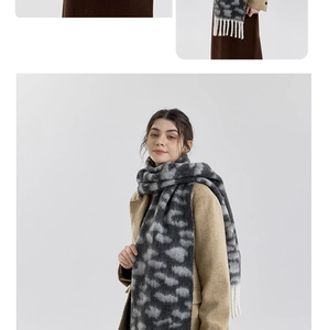 Detail of soft leopard print scarf with white tassels worn over a beige wool coat