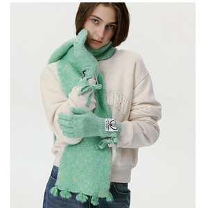 Detail von minzgrünem Strickschal mit Fransen und passenden Schleifen-Handschuhen