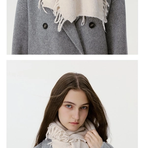 Detailed close-up of solid color wool blend knit scarf with tassels and coat buttons