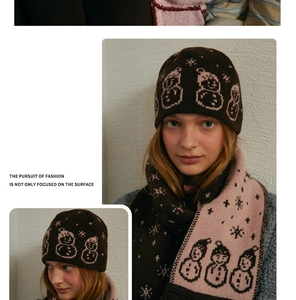 Detail of wool blend knitted scarf and hat set with snowman jacquard and fringe edges