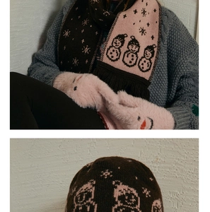 Close-up of winter knit set with snowman jacquard pattern and pink plush mittens