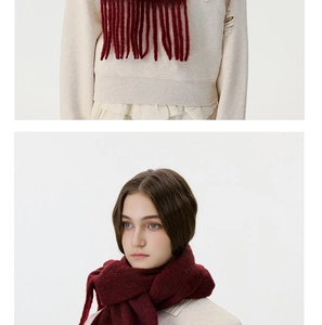 Detailed macro shot of burgundy winter scarf fringe and cozy wool material texture