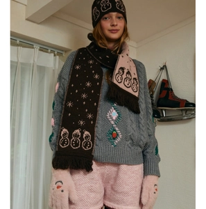 Close-up of winter knit beanie and scarf set featuring cute snowman jacquard pattern