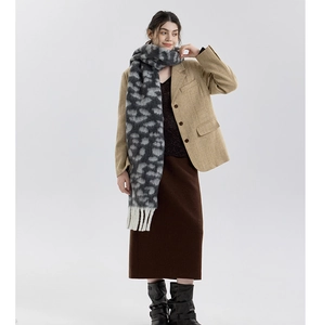 Detailed view of leopard print scarf with cream fringe worn by model in a chic fall outfit