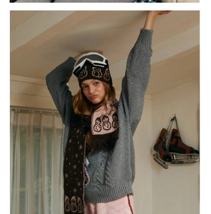 Winter set with snowman jacquard scarf and matching knitwear in a cozy indoor setting