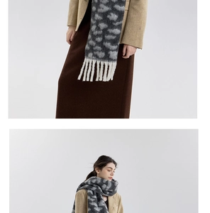 Detail of leopard print knitted scarf with long white tassels and soft texture finish