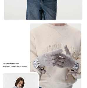 Detail von grauen Strickhandschuhen mit modischer Schleife und gewebtem Textiletikett