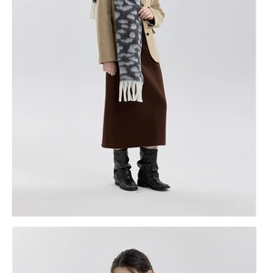 Styling detail of a soft leopard print tassel scarf paired with a wool blazer and boots