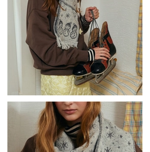 Detailed knit texture of a snowman pattern scarf with vintage winter snowflake motifs