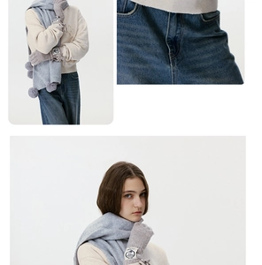Detailansicht von Strickschal mit Pompons und passenden Handschuhen mit Webetikett
