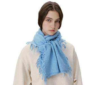 Sky blue wool blend knit scarf with long tassels worn by female model on white background
