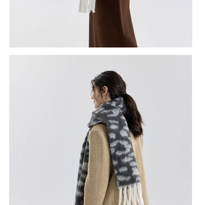 Detail showing soft leopard print and white tassel texture on a warm winter scarf
