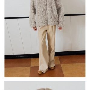 Detail view of stylish grey faux fur jacket and ruffled wide leg trousers outfit