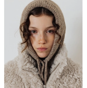 Close-up of tan knitted balaclava texture and off-white fuzzy sherpa fleece jacket detail