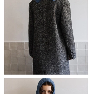 Detail of herringbone wool coat fabric texture and blue knit balaclava hood contrast