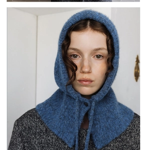 Detail of dark blue knit balaclava showing thick wool texture and front neck ties