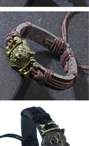 Détail d'un bracelet en cuir vintage avec tête de loup en bronze et breloques en métal